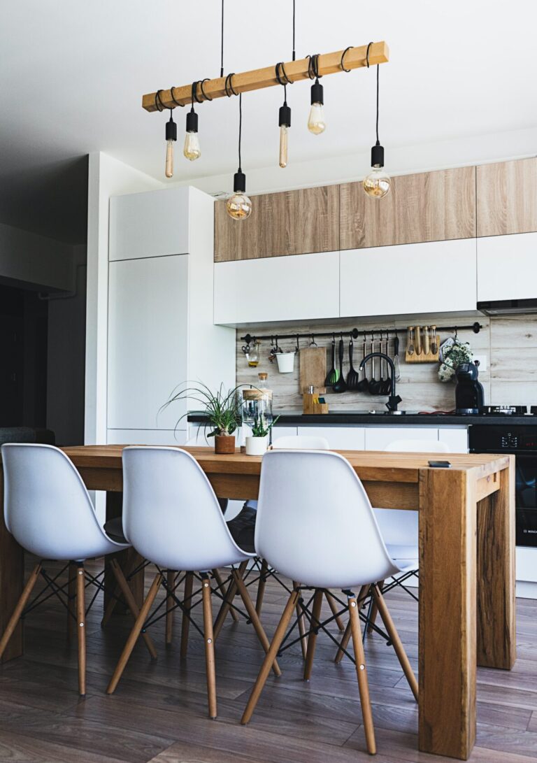een keuken met een houten tafel en witte stoelen.