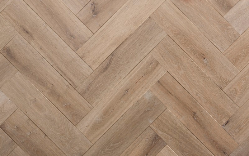 een close-up van een houten vloer met een chevronpatroon.