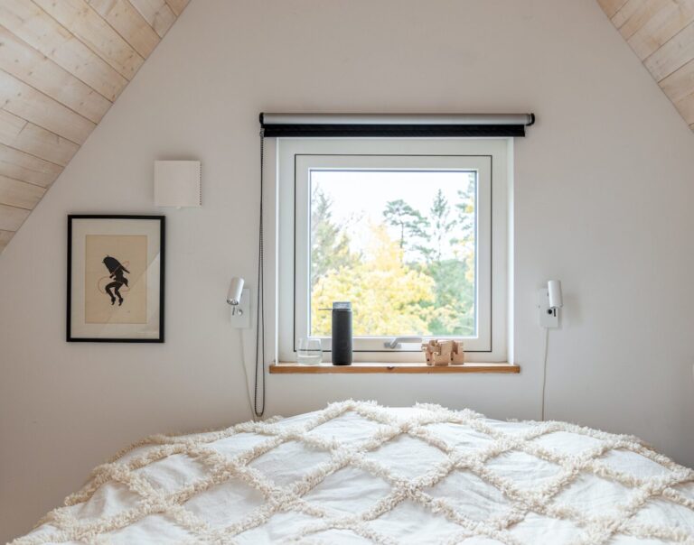 een slaapkamer met een bed en een raam op zolder